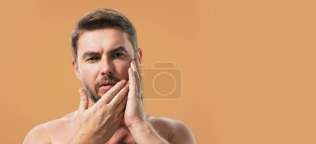 Closeup portrait of attractive man with cream on face. Beautiful man close up portrait on white background. Banner for header, copy space. Poster for web design