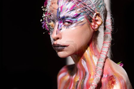 Photo for The Arts. Art Portrait of young woman with art make-up. The Body Art. Abstract face paint. Model with creative art makeup. Creative body paint and hairdo. Woman in paint. Attractive female Face draw - Royalty Free Image