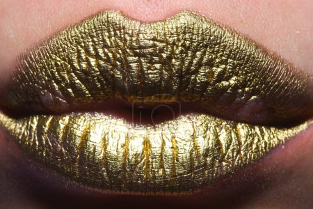 Foto de Gold lips, golden lipgloss on sexy lips, metallic mouth. Beauty woman mouth. Sexy girl golden lips, gold mouth. Glowing gold skin and gild lips. Metallic shine golden lip gloss - Imagen libre de derechos
