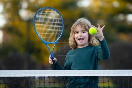 Téléchargez les photos : Enfant jouant au tennis sur le terrain. Enfant jouant au tennis dans un club sportif. Exercice actif pour les enfants. Activités sportives pour les enfants. Formation pour les jeunes enfants. Apprendre le tennis aux enfants - en image libre de droit