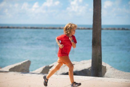 Photo for Little runners outdoors in summer nature. Sporty child running in a park. Outdoor sports and fitness for children - Royalty Free Image