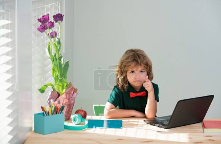 Téléchargez les photos : Child boy in room at home school. Education, elementary school, learning and people concept. Kid using laptop, study online, homeschooling - en image libre de droit
