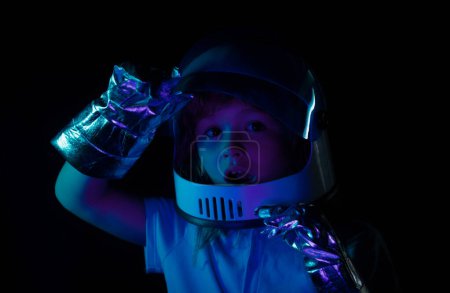 Téléchargez les photos : Enfant garçon s'imagine être un astronaute dans un casque spatial. Gros plan excité enfants visage - en image libre de droit