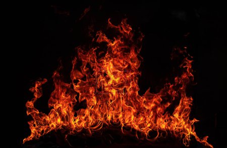 Foto de Fuego llama llamas sobre fondo negro. Fuego quemar llama aislada, textura abstracta. Efecto explosión llameante con fuego ardiente - Imagen libre de derechos