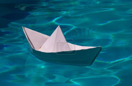 Téléchargez les photos : Navire en papier, navire en papier origami voile. Bateau en papier sur fond d'eau de mer. Rêver voyager - en image libre de droit