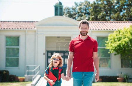 Téléchargez les photos : Père et fils traversant le parc scolaire - en image libre de droit