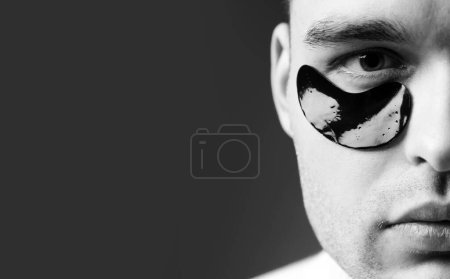 Photo for Man face with flakes under the eyes. Mans flakes. Patches under close eyes for man. Close up portrait of charming man applying patches under close eyes. Wellbeing concept - Royalty Free Image
