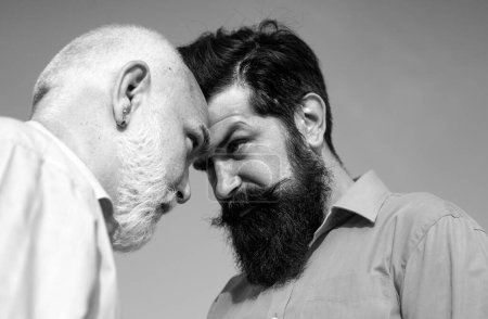 Photo for Men generations: grandfather and father together. Elderly Senior man and bearded son - two generation concept. Father and son looking at each other - Royalty Free Image