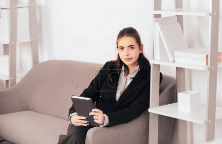 Young businesslady at workplace in the office. Beautiful secretary woman in formal wear working on project at modern office