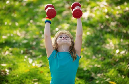 Photo for Fitness child. Funny child lifting the dumbbells in backyard outside. Kids in training - Royalty Free Image