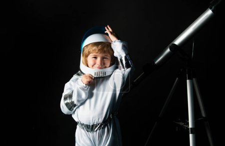 Téléchargez les photos : Adorable mignon garçon astronaute dans l'espace. Enfant s'imagine être un astronaute dans un casque d'astronautes. Portrait d'enfant drôle avec casque astronaute - en image libre de droit