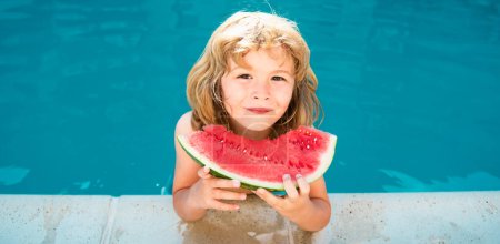 Téléchargez les photos : Mignon petit garçon dans la piscine mangeant pastèque. Profitez de manger des fruits tropicaux. Concept pour enfants d'été. Bonne enfance - en image libre de droit
