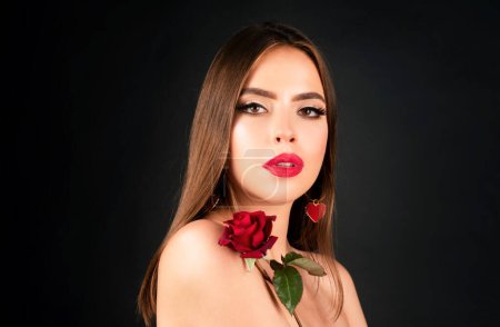 Téléchargez les photos : Portrait de mode beauté. Belle femme avec maquillage et fleurs roses sur fond noir isolé. Inspiration du printemps et de l'été. Concept cosmétique parfum - en image libre de droit