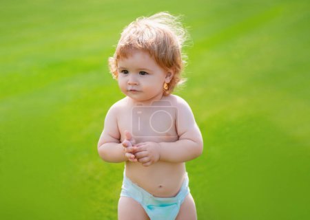 Photo for Happy baby in diaper having fun at the park. Funny baby child. Funny little child closeup portrait on green grass background - Royalty Free Image