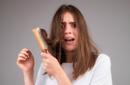 Foto de Mujer caída del cabello con un peine y cabello problemático. Peinado mujer estresada y problemas calvos - Imagen libre de derechos
