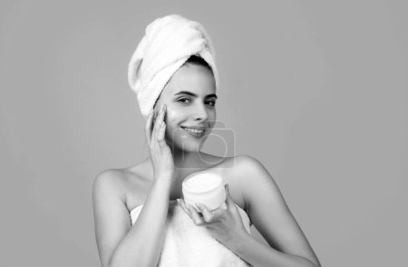 Schönheit Frau mit kosmetischen Produkten reinigen gesunde natürliche Haut. Porträt eines attraktiven jungen Mädchens mit einem Badetuch auf dem Kopf. Schöne Frau Gesicht Porträt
