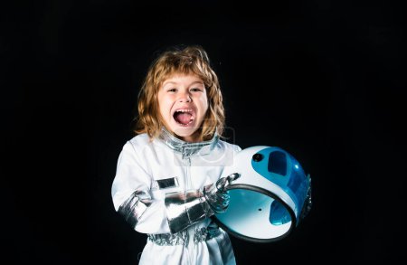 Téléchargez les photos : Concept cosmonaute pour enfants de l'espace. Portrait de positif excité petit garçon portant un casque avec joie. Fond isolé avec espace de copie - en image libre de droit