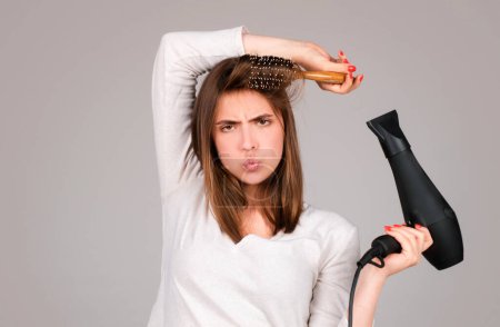 Photo for Woman with hair dryer. Beautiful girl with straight hair drying hair with professional hairdryer. Haircare concept - Royalty Free Image