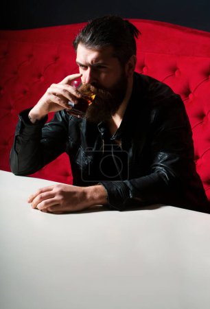 Photo for Drunk guy having problem from alcohol addiction abuse, alcoholism concept. Bearded hipster man drinking whisky, whiskey or cognac brandy - Royalty Free Image