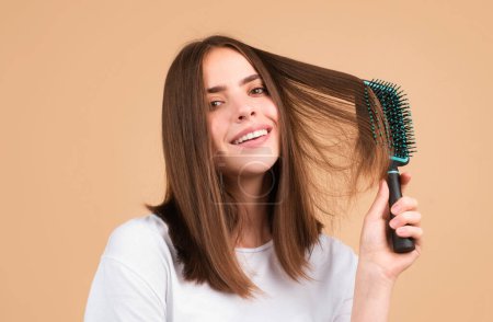 Foto de Mujer joven peinando cabello brillante sano y natural, aislado en el estudio. Belleza cuidado del cabello - Imagen libre de derechos