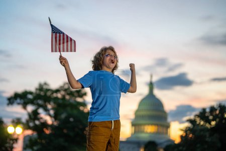 Foto de Día de la independencia del 4 de julio en Estados Unidos. Niño con bandera estadounidense el 4 de julio en Washington DC. Fiesta americana 4 de julio. Bandera de los Estados Unidos cerca del Capitolio. América celebra el 4 de julio - Imagen libre de derechos