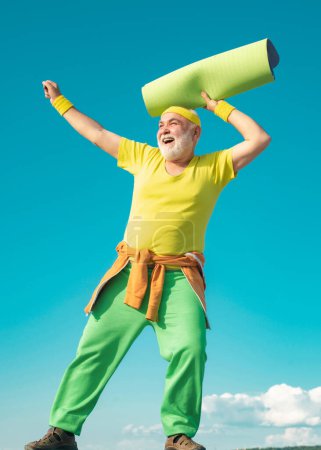Photo for Funny sporty old sportsman finished his work out. Healthcare cheerful lifestyle. Like sports. Sport. Happy active old man holding exercise mat - Royalty Free Image