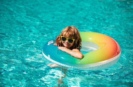 Foto de Vacaciones de verano. Fin de semana de verano. Chico divertido en piscina de natación en círculo de goma inflable en aquapark - Imagen libre de derechos