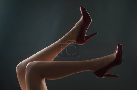 Legs in red heels. Fashion shoes style. Girl sexy slim feet
