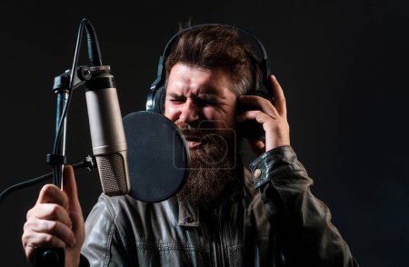 Photo for Man with microphone singing song. Musician in music hall. Expressive face closeup - Royalty Free Image