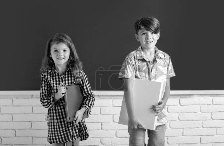 Téléchargez les photos : Back to school. Cute little children girl and boy studying in classroom at elementary school - en image libre de droit