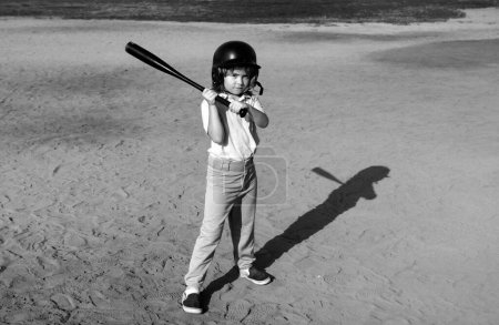 Child batter about to hit a pitch during a baseball game. Kid baseball ready to bat