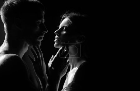 Photo for Beautiful loving couple posing on dark backgroung with night lights. Sensual portrait of a sexy couple embracing while dating. Young couple in love on black. The lovely coupl spends time together - Royalty Free Image