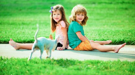 Téléchargez les photos : Enfants jouant en plein air avec un petit chien au parc. Adaptation des enfants - en image libre de droit