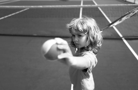 Foto de Niño jugando al tenis. Niños deportivos. Niño con raqueta de tenis en pista de tenis. Formación para niños pequeños, niños sanos - Imagen libre de derechos