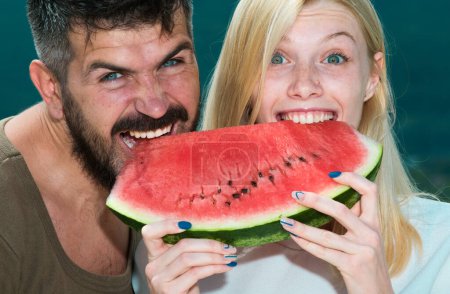 glückliches sorgenfreies Paar isst Wassermelone. Vitamine und gesundes Konzept. genießen eine Wassermelone. Freunde des Paares essen eine Wassermelonenscheibe und lachen zusammen. Urlaub