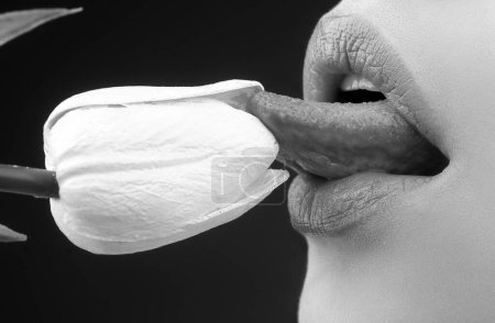 Foto de Oral sex, licking flower. Sexy lips with tulips. Blowjob and kiss, sensual tongue licks tulip. Sexy female mouth and spring flowers - Imagen libre de derechos