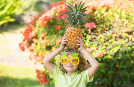 Photo for Pineapple child boy and pineapples on summer vacation - Royalty Free Image