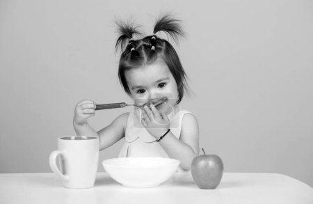 Photo for Cute funny babies eating, baby food, Kid girl eating healthy food - Royalty Free Image