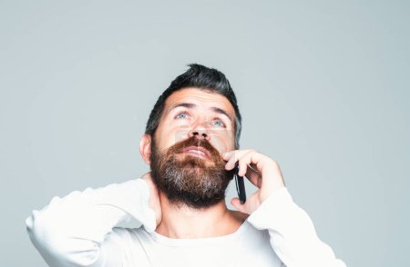 Foto de Hombre barbudo hablando por teléfono. Comunicaciones - Imagen libre de derechos
