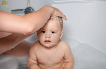 Téléchargez les photos : Bain bébé. Enfant heureux avec de la mousse de savon sur la tête. Todler dans la douche, drôle de bébé dans la douche - en image libre de droit
