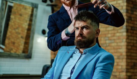 Hair style and hair stylist. Barber making haircut of attractive bearded man in barber shop. Shaving man and razor man. Vintage barber shop shaving. Moustache Wax