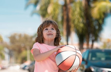 Téléchargez les photos : Le gamin s'est concentré sur le basket. Sport pour enfants - en image libre de droit