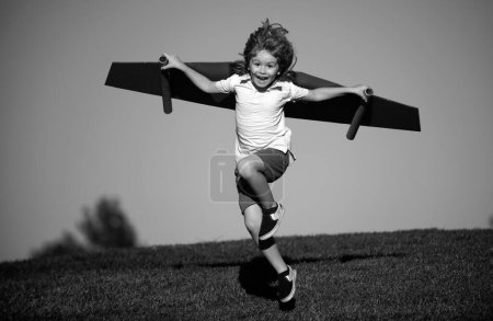 Photo for Child to be pilot. Kid with paper wings flying. Summer vacation and travel concept. Funny child boy with toy cardboard airplane wings fly on sky. Startup freedom and kids carefree concept - Royalty Free Image