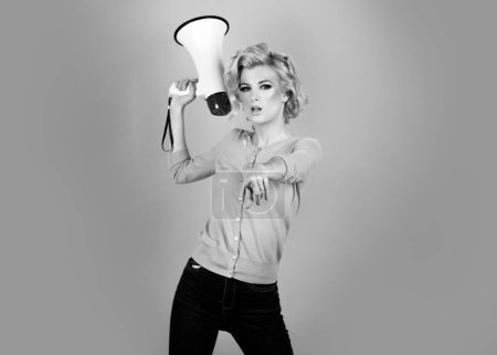 Pretty girl shouting into megaphone isolated, copy space. Idea for marketing or sales banner