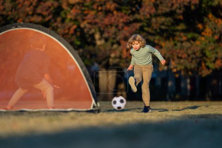 Child boy hold classic football ball in park. Kid hold football ball, banner. Kid with football ball. Sport, soccer hobby for kids. Little football player posing with soccer ball