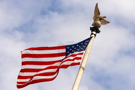 Téléchargez les photos : Drapeau américain agitant dans le ciel bleu États-Unis. Drapeau agitant. Jour de l'indépendance. Le 4 juillet. Le concept du drapeau américain - en image libre de droit