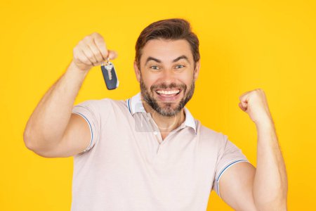 Photo for Excited Businessman with key. Real estate agent hold keys on yellow. Real estate man hold keys. Man broker or real estate agent with keys. Business man in t-shirt show keys. Car Key or house Key - Royalty Free Image