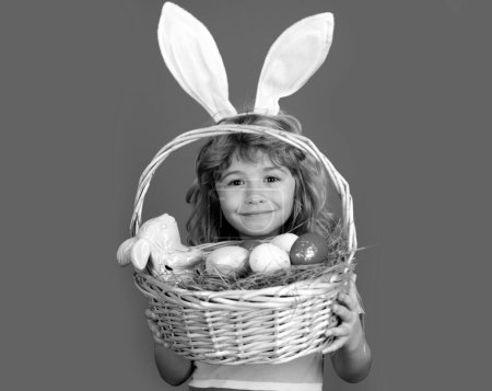 Kid boy with easter basket isolated on blue background. Happy Easter. Easter bunny children