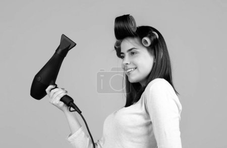 Téléchargez les photos : Femme avec sèche-cheveux isolé en studio. Belle fille avec cheveux raides sèche-cheveux avec sèche-cheveux professionnel - en image libre de droit