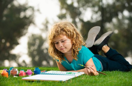 Photo for Child boy drawing in summer park, painting art. Little artist painter draw pictures outdoor. Children hobby, happy childhood - Royalty Free Image